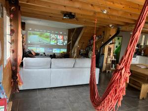 a living room with a white couch and a hammock at Maison de campagne à Gap avec vue sur la montagne. in La Freissinouse