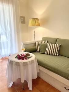 ein Wohnzimmer mit einem grünen Sofa und einem Tisch in der Unterkunft Casa da Palmeira Porto Santo in Vila Baleira