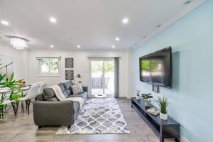 a living room with a couch and a tv on a wall at 4BR Scarborough Gem, Freshly Renovated, 7 Car Parking in Toronto