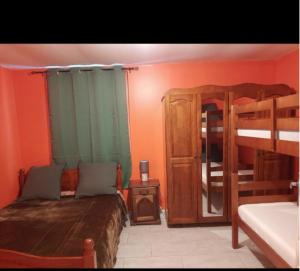 a bedroom with two bunk beds and a mirror at Pomme de Pin in Cilaos