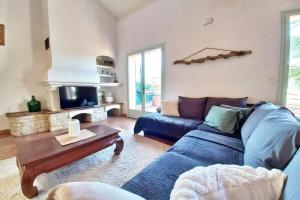 Una sala de estar con un sofá azul y una mesa. en Family house - quiet - common pool - Fréjus, en Fréjus
