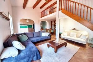 Una sala de estar con un sofá azul y una escalera. en Family house - quiet - common pool - Fréjus, en Fréjus 14 fotos más