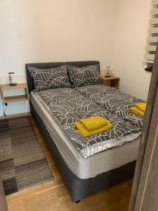 兹拉蒂博尔Natali Apartman的一张床上有两个黄色枕头的房间