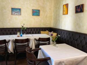 two tables in a restaurant with white tables and chairs at Augusta Trarbach in Traben-Trarbach
