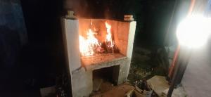 a brick fireplace with a fire in it at night at Cascina Vittorio, Relax in campagna con barbecue vicino Gallipoli in Noha +61 photos