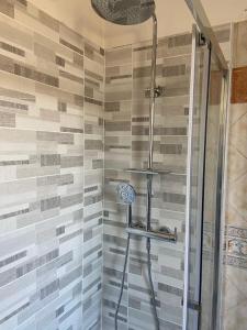 a shower in a bathroom with a tile wall at Casa degli Orti in Bra