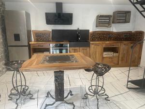 a kitchen with a wooden table and some chairs at Le Cabistou in Saint-Saturnin