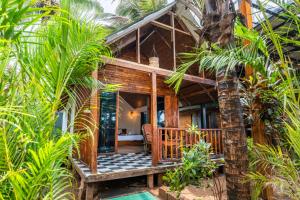 a house in the middle of a forest with palm trees at Simrose in Agonda