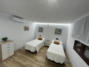 a room with two beds and a dresser in it at 2ª planta D Apartamento Juan Robledo en centro ciudad, INTERIOR in Andújar