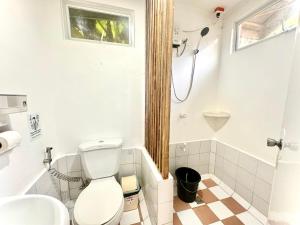 a bathroom with a toilet and a sink and a shower at RRJ Bungalow 2 1BR,2AC 4 mins walk to the beach in General Luna