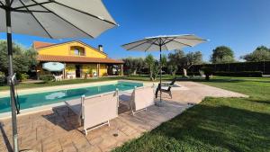 a swimming pool with two chairs and an umbrella at Giardino tra gli ulivi in Treglio
