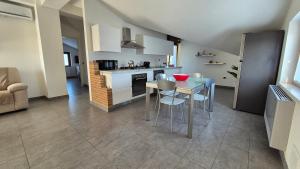 a kitchen with a table and chairs and a kitchen with a stove at Giardino tra gli ulivi in Treglio