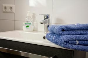 a bathroom with blue towels on a sink at Ferienwohnung Karolus in Sinsheim +9 photos