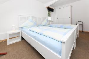 a large white bed in a room with a table at Ferienwohnung auf dem Hof Tjarks in Friedrichsschleuse +8 photos