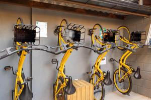 a group of three yellow bikes hanging on a wall at Casa Container-Piscina-AC-30min até Aeroporto in Florianópolis