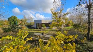 a house with a picnic table in the middle of a field at La Maison Fleurie - Sunny holiday home with large garden, parking, within walking distance of the sea in Koksijde