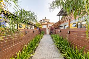 a walkway through a fence with plants at Casa Container-Piscina-AC-30min até Aeroporto in Florianópolis