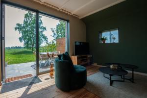 a living room with a chair and a television at Appartement met fantastisch uitzicht in Ellertshaar