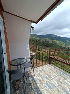 a balcony with a table and chairs and a bench at Baan Phak Sai Lom Nao in Ban Maeo Thap Boek