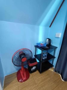 a blue room with a red fan and a table at Baan Phak Sai Lom Nao in Ban Maeo Thap Boek