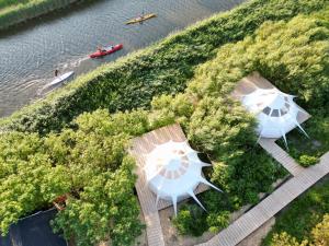 two white umbrellas on a path next to the water at Agger Glamping - Fyret in Vestervig
