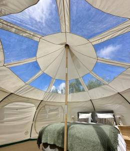 una camera da letto in una tenda con una grande finestra di Agger Glamping - Fyret a Vestervig