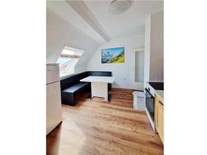 a kitchen with a white table and a bench at Wohnung Beth im Dachgeschoss mit Balkon in Lonnerstadt