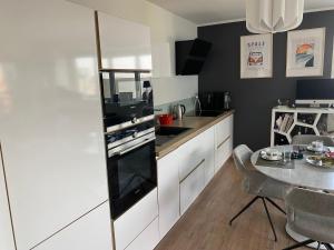 a kitchen with white cabinets and a table in it at Fred Appartement Lille Centre in Lille