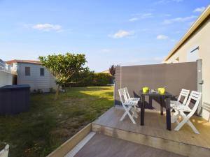 a patio with a table and chairs on a fence at Maison pour 4 entre plages et marais salants in Les Bussolleries +10 photos