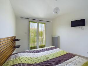 a bedroom with a bed and a tv on the wall at Maison pour 4 entre plages et marais salants in Les Bussolleries