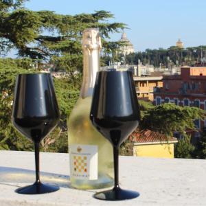 a bottle of wine sitting between two wine glasses at Anita's House in Rome