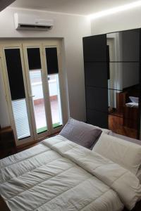 a bedroom with a large white bed with windows at Anita's House in Rome