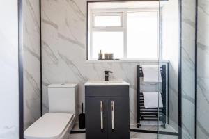 a bathroom with a sink and a toilet and a window at 2 Bedroom House in Seaham - Driveway Parking in Seaham +44 photos