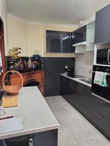 una cucina con mobili neri e un piano di lavoro di Quinta Da Felicidade a Várzea