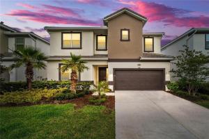 a house with a garage and palm trees at Magic Kingdom Villa - Private Master Bedrooms in Kissimmee