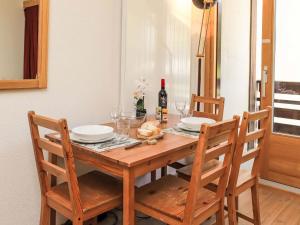 a wooden table with two chairs and a bottle of wine at Apartment Rosablanche C22 by Interhome in Siviez +16 photos