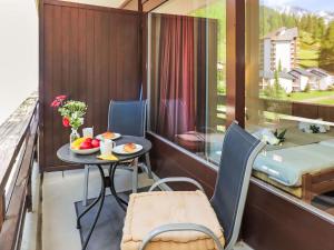 a balcony with a table and chairs and a bed at Apartment Rosablanche C22 by Interhome in Siviez