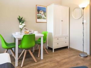 a dining room with a table and green chairs at Apartment Rosablanche C66 by Interhome in Siviez