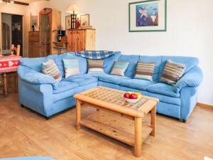 a blue couch in a living room with a table at Apartment Rosablanche D51 by Interhome in Siviez