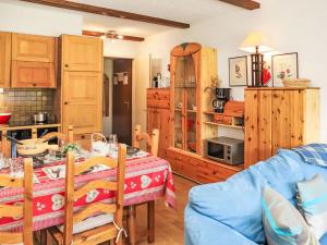 a kitchen and dining room with a table and a blue couch at Apartment Rosablanche D51 by Interhome in Siviez