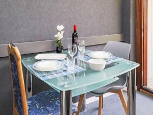 a table with plates and glasses and a bottle of wine at Apartment Rosablanche B22 by Interhome in Siviez