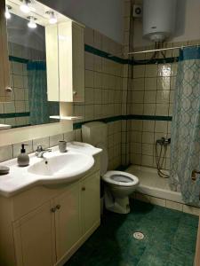 a bathroom with a sink and a toilet and a mirror at See view apartment in Dhimínion +21 photos
