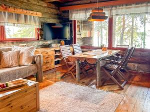 ein Wohnzimmer mit Tisch, Stühlen und Sofa in der Unterkunft Holiday Home Nanguvilla by Interhome in Veskoniemi