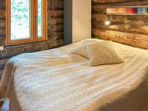 ein Schlafzimmer mit einem Bett mit Bettdecke und einem Fenster in der Unterkunft Holiday Home Nanguvilla by Interhome in Veskoniemi