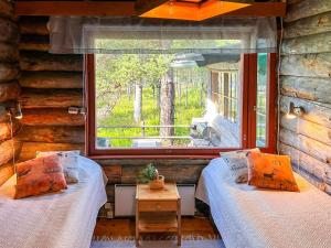 zwei Betten in einem Zimmer mit großem Fenster in der Unterkunft Holiday Home Nanguvilla by Interhome in Veskoniemi