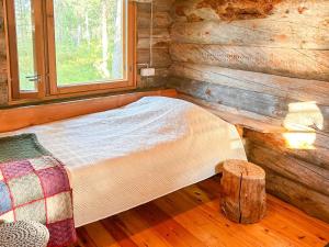 Bett in einem Blockhaus mit Fenster in der Unterkunft Holiday Home Nanguvilla by Interhome in Veskoniemi + 16 Fotos
