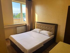 una camera da letto con un letto con una grande finestra di Express Hotel a Yerevan