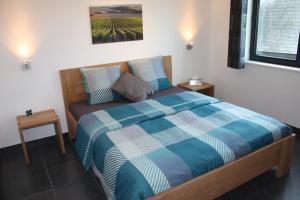 a bedroom with a bed with a blue and white comforter at Hotel Gasthof Kapelhof in Erpe-Mere