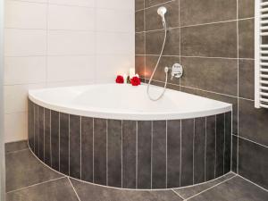 a bath tub with a shower in a bathroom at Apartment Rosablanche D 203A by Interhome in Siviez