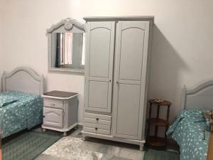 莫纳斯提尔Maison avec vue mer La falaise的一间卧室，有两张床和一个白色的大柜子